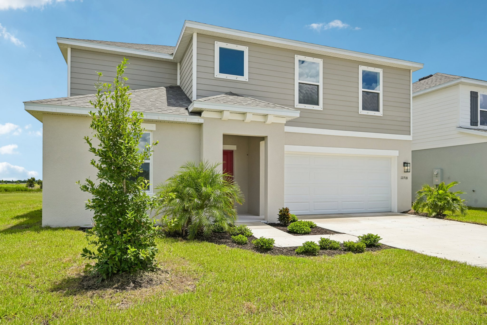 Two-story Deer Park home exterior with two-car garage and palm landscaping
